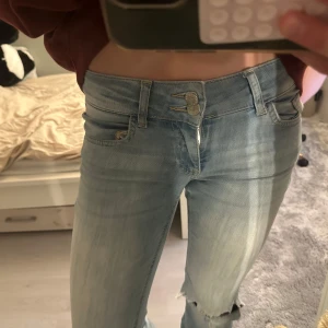 Nelly jeans  - Snygga Nelly jeans med hål i knäna, low waist. Strl 34, midjemått 35 cm 