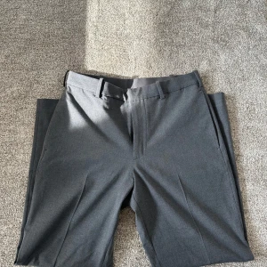 Grå kostymbyxor - Snygga grå kostymbyxor från uniqlo med raka ben. Byxorna har aldrig blivit använda och därför i nyskick. Nypris 599 mitt pris 199. 