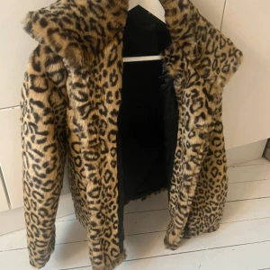 Leopardmönstrad pälsjacka - Säljer en snygg leopardmönstrad pälsjacka som är perfekt för att sticka ut. Jackan har långa ärmar och en mysig känsla. Perfekt för kyligare dagar när du vill ha en djärv stil.