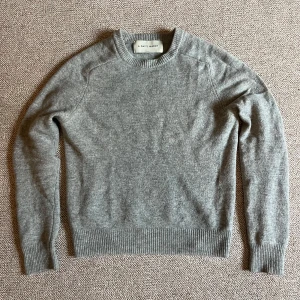 Grå tröja från A Day's March - Säljer en stilren grå tröja från A Day's March. Tröjan har en klassisk rund halsringning och är tillverkad i ett mjukt material. Perfekt för en avslappnad och snygg look.