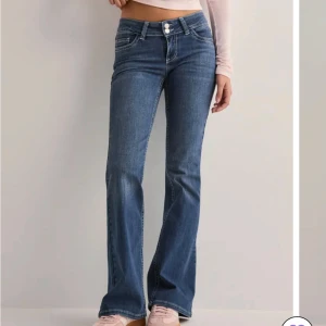 Blå bootcut jeans - Snygga blå bootcut jeans med låg midja. Jeansen har en stilren look med dubbla knappar i midjan. Stl 36, helt i nyskick säljer då jag inte hann skicka tillbaka dom då dom var förstora. Nypris 700kr