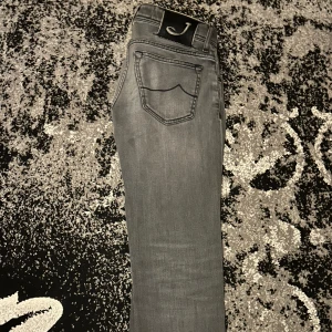 Grå jeans från Jacob Cohen Nästan helt nya!! - Snygga grå jeans från Jacob Cohen med en klassisk femficksdesign. De har en normal passform och är tillverkade i ett mjukt och bekvämt material. Perfekta för en stilren look.