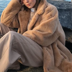 Beige pälsjacka från Stradivarius - Säljer en supermjuk och stilren beige brun pälsjacka från Stradivarius. Jackan har en klassisk krage och långa ärmar, perfekt för kyliga dagar. Den är både trendig och bekväm, ett måste i garderoben! 🐻Ord pris ~800