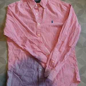 Rosa Ralph Lauren Skjorta Storlek: M - Säljer nu min rosa Ralph lauren skjorta som mest legat i garderoben senaste tiden. Den är använd ett fåtal gånger. Skicket på denna är mycket bra, inga skavanker alls, slim fit.  Nypris runt 1700 kr Priset är diskuterbart