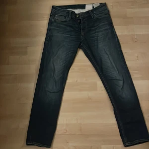 Mörkblå jeans från Jack & Jones - Säljer ett par mörkblå jeans från Jack & Jones. De har en klassisk femficksdesign och en snygg tvättad look. Perfekta för en avslappnad stil. Midjan är normal och passformen är straight.