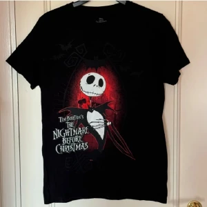 The Nightmare Before Christmas Tröja - Säljer en svart T-shirt från Disney med motiv från Tim Burton's The Nightmare Before Christmas. T-shirten är kortärmad och tillverkad i 100% bomull. Säljer då den inte kommer till användning