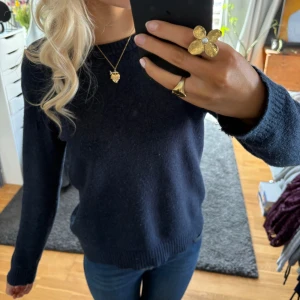 Mörkblå stickad tröja - Säljer en stilren mörkblå stickad tröja med långa ärmar och ribbade ärmar