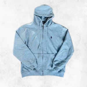 Grå zip hoodie från Polo Ralph Lauren - Säljer en stilren grå zip hoodie från Polo Ralph Lauren med dragkedja och klassisk logga på bröstet. Det är storlek M men sitter mer som en S. Hoodien är i mycket bra skick utan några defekter. Vid några frågor eller mer bilder är det bara att höra av sig.