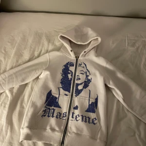 Vit hoodie med tryck - Säljer en vit hoodie med ett  tryck på Marlyn Monroe på framsidan. Hoodien har dragkedja och långa ärmar, perfekt för en avslappnad stil. Hör av dig vid intresse!