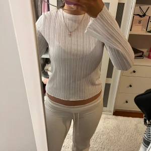 Vit ribbad tröja - Säljer en stilren vit ribbad tröja med långa ärmar. Perfekt för en avslappnad look. Tröjan har en normal passform och är tillverkad i ett mjukt material.