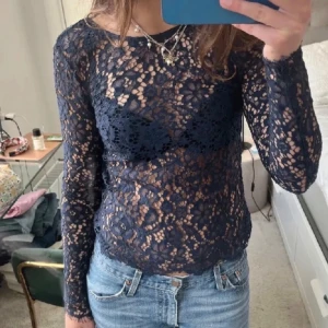 Blå spetsblus - Säljer en elegant blå spetsblus med långärmad design. Blusen har ett vackert blommigt mönster och en figurnära passform. Perfekt för att lägga till en touch av stil till din garderob. Använd max 3ggr💕💙