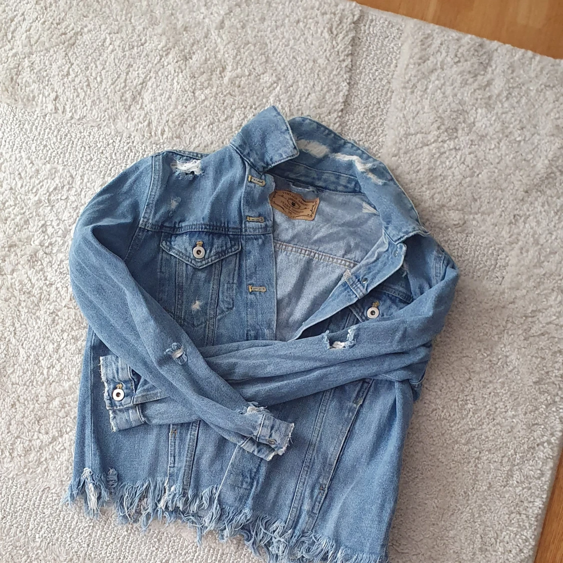 Blå jeansjacka med slitningar - 1