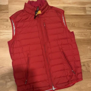 Parajumper väst - Parajumper väst med en nice röd färg perfekt för det här vädret, västen är i bra skick och inga fel.