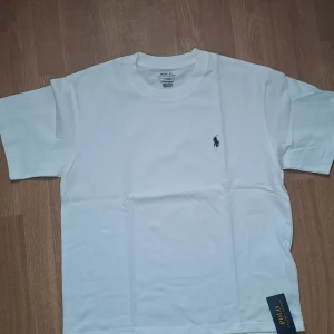 Ralph Lauren tshirt - Helt ny vit t-shirt från Ralph Lauren med klassisk rund hals och broderad logga på bröstet. Storlek S. Perfekt för en clean och stilren look.
