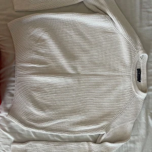 Vit stickad tröja från S.C.W. - Säljer en stilren vit stickad tröja från S.C.W. i storlek S. Tröjan har rund halsringning, ribbade muddar och lång ärm. Perfekt för lager-på-lager och enkel att matcha med jeans.