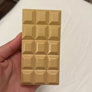 Sweet Tooth parfym av Sabrina Carpenter - Sweet Tooth by Sabrina Carpenter är en parfym i en unik beige flaska formad som en chokladkaka. Flaskan är tillverkad i plast med geometriska rutor och har en guldig spraytopp. Perfekt för dig som gillar söta och lekfulla dofter och vill ha en cool flaska på hyllan.