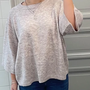 Beige stickad tröja från 157 - Mysig beige stickad tröja från 157 med rund hals och trekvartsärm. Tröjan har en loose passform och är perfekt för dig som gillar en chill och enkel stil. Kommer inte till användning mer🤍