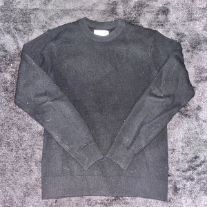 Svart merinoull tröja med rund hals - Tröjan är XS men passar mer som en S.                                  En stilren svart merinoull tröja med rund hals och långa ärmar. Tröjan har en klassisk passform och ribbade muddar vid ärmslut och nederkant. Perfekt att slänga på sig när det är lite kyligt ute. Enkel att matcha med jeans eller chinos.