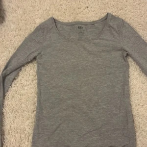 2-pack långärmade tröjor från 157 - Tre basic långärmade tröjor från 157 i storlek S. En är grå, en svart och en är vit, alla med rund halsringning och smal passform. Tillverkade i mjuk bomull med lite stretch för extra komfort. Perfekta att styla med jeans eller kjol.