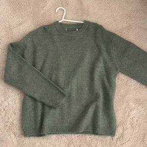 Stickad tröja  - Mysig grön stickad tröja med rundad hals och ribbade muddar vid ärmslut och nederkant. Köpt från LAGER 157 men har dock klippt av lappen.  Extremt skönt material, och den är använt endast 1 gång utan några som helst skavanker!!! 