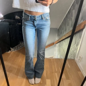 Blå low waist bootcut jeans ifrån junkyard - Säljer ett par ljusblå bootcut jeans från junkyard. Jeansen är lågmidjade, klassiska och har snygga broderade bakfickor! 💗