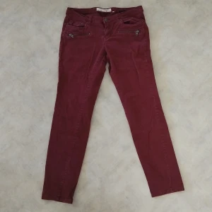 Vinröda manchesterbyxor H&M L.O.G.G. - Snygga vinröda manchesterbyxor från H&M L.O.G.G. i storlek 42. Byxorna har smal passform, dragkedjor framtill och klassisk femficksdesign. 
