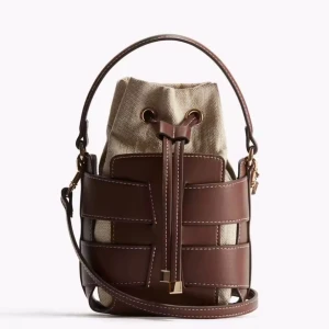 Brun och beige axelväska med snörning - Snygg axelväska i bucket-modell med bruna skinnpaneler och beige canvas. Trendiga HM väskan säljer jag eftersom den inte kommer till användning. Pris kan diskuteras
