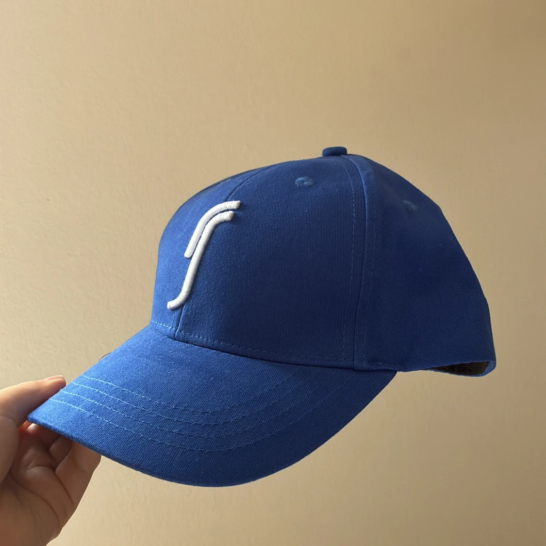 Blå keps med vit logga från Racquet Sports