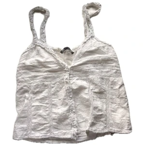 Zaratopp med spetsdetaljer - Superfin vit broderad linnetopp med smala axelband och dekorativa knappar framtill. Toppen har spetsdetaljer och ett romantiskt, bohemiskt uttryck. 💕💕