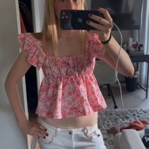 Blommig rosa volangtopp  - Supersöt blommig topp!!❤️❤️.Modellen är croppad och har breda axelband som även kan bäras offshoulder. 