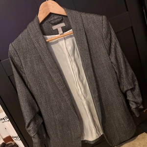 Grå kavaj i bra skick - Nästan ny använd knappt har fin detaljer på armen