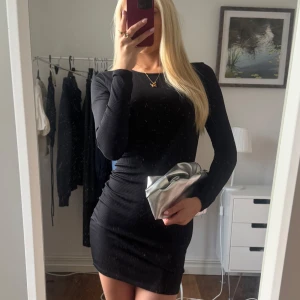 Svart ribbad kortklänning - Säljer en svart ribbad kortklänning med långa ärmar. Från Nelly Trend i storlek S
