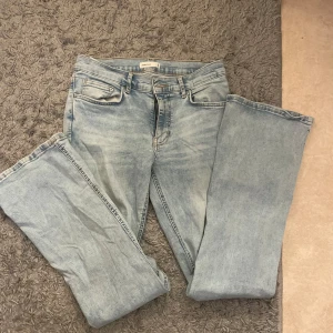 Ljusblå low bootcut  jeans från gina tricot - Säljer ett par ljusblå jeans från gina tricot med klassisk femficksdesign och raka, vida ben. Jeansen har låg/mid midja och är tillverkade i mjukt denimtyg. Storlek 40 och passar perfekt till mej som är 169. Säljer pga ingen användning.🥰🥰orginal pris 50€/500kr