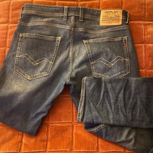 Replay Grover jeans i mörkblå denim - Säljer ett par Replay Grover jeans i mörkblå tvätt. Klassisk femficksmodell med raka ben och normal passform. Tydliga kontrastsömmar och Replay-logga på bakfickan. Perfekta jeans för dig som gillar stilren och avslappnad look.