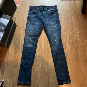 Jack & Jones slim fit Glenn - Snygga blå jeans från Jack & Jones med slitna detaljer i modellen Glenn. Modellen är slim fit och storlek 30W/34L. Säljer för att de är för små. Skriv vid frågor/intresse!