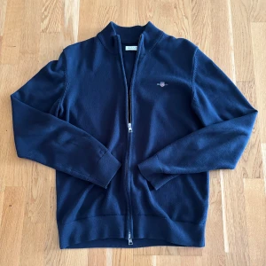 Gant full zip - Säljer min full zip tröja från gant. Den är mörkblå och är i väldigt fint skick då jag har använt den max 4 gånger. Är storlek 176 men passar som en S. Bara att höra av sig vid frågor eller funderingar.