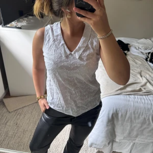 Kortärmad blus - Säljer en söt vit blus från Mohito Collection i storlek 34. Blusen har v-ringning och är ärmlös med broderade blommor i tyget. Perfekt för vår och sommar, lätt och luftig modell.