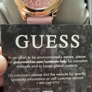 Guess damklocka i roséguld med glittriga detaljer - Lyxig damklocka från Guess i roséguld med glittrande stenar runt boetten och på armbandet. Urtavlan har en skimrande lila och silverfärgad bakgrund med flera små urtavlor och tydliga indexmarkeringar. Perfekt accessoar för att sticka ut.Pris i butik 3300kr