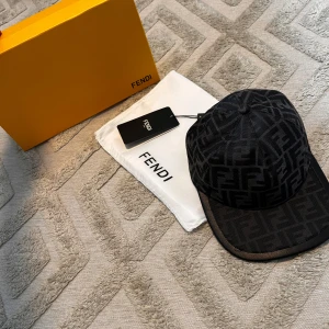 Svart keps från Fendi med monogram - Snygg svart keps från Fendi med deras klassiska FF-monogram i grått över hela kepsen. Justerbar baktill för perfekt passform. Perfekt accessoar för att lyfta din stil med en lyxig touch.Helt nytt och är perfekt till sommaren.                                                             Aktiv 24/7✅ Skickas inom 24h📦🚚 Kan gå ner i hugget 😃✅ Hör av er via frågor⁉️