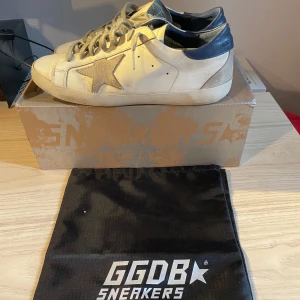 GGDB Superstar sneakers med stjärndetalj - Hej, jag säljer ett par golden goose super star I strl 41-42 och är i skick 8/10 om du frågar mig!   Den kommer med originalpåse och låda. Kontakta mig vid minsta frågor! Pris kan diskuteras! 