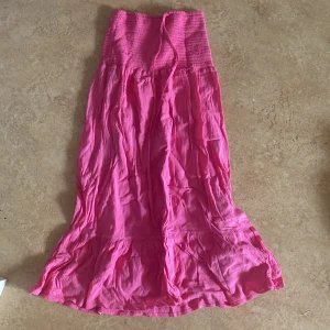 Rosa långklänning med smock - Säljer en söt rosa lång kjol med smock upptill och volang ner till.