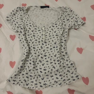 Tshirt från Brandy Melville - Cute tröja från Brandy med knappar och blåa blommor. Använd några gånger men inga defekter. Pris kan diskuteras 