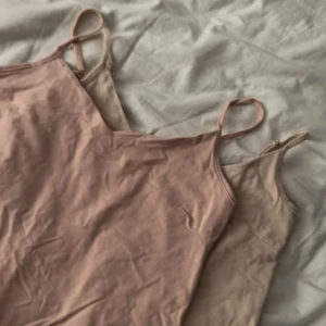 Två linneklänningar i rosa och beige - Säljer två enkla linnen med smala axelband, en i ljusrosa och en i beige. Perfekta för varma dagar eller som basplagg. Mjukt och stretchigt material som sitter bekvämt på kroppen. Storlek S på båda 