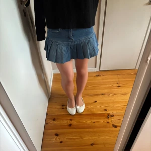 Blå jeanskjol med volanger  - Midjemåttet rakt över är 34 cm och längden uppifrån och ner är ca 30 cm💗