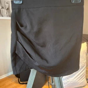 Svart kortkjol - Säljer en svart kortkjol från New Yorker. Kjolen har en enkel och stilren design med rak passform och dragkedja bak. Perfekt att matcha med olika toppar för en trendig look.🩷 Storlek XS 🌸