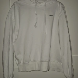 Vit hoodie från H&M Divided, strl S - Vit hoodie från H&M Divided med svart text 'original' på bröstet. Klassisk modell med huva och snörning, ribbade muddar och mjukt material. 