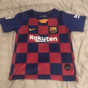 FC Barcelona Messi 10 matchtröja Nike - Barça-fans! Säljer en officiell FC Barcelona matchtröja från Nike med Messi 10 på ryggen. Tröjan har klassiskt rödblått rutmönster, korta ärmar och klubbmärke på bröstet. Materialet är lätt och andas, perfekt för fotboll eller att bära på läktaren.