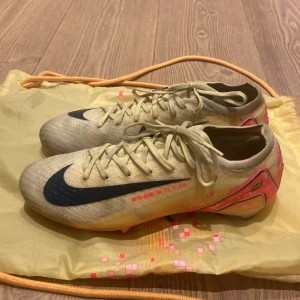 Nike Mercurial Superfly Elit strl 39 + originalpåse - Säljer mina Nike Mercurial Superfly Elit – en av Nikes bästa fotbollsskor! Snygg färg i beige/gult med svart swoosh och röda detaljer. Använda men i bra skick och redo för nya matcher ⚽️.nypris cirka 2800 mitt pris 899.  påsen ingår! 