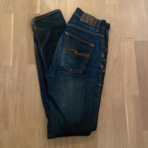 Nudie Jeans Grim Tim blå jeans - Säljer ett par mörkblåa Nudie Jeans Grim Tim. De är i storlek 30/32 och är i väldigt bra skick. Passar mig som är 180. Eftersom de är så pass eftersökta är priset 500. 