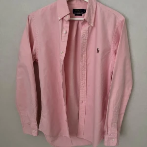 Rosa Ralph Lauren Skjorta - Slim fit - S - Skön Ralph lauren skjorta i storlek S i den sjukt eftertraktade modellen Slim fit. Skjortan har inga defekter överhuvudtaget och är i 10/10 skick - så gott som ny. Säljer då den inte passar och pris kan diskuteras vid snabb affär. Vid frågor eller funderingar hör gärna av dig :)